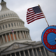 WASHINGTON, DC - JANUARY 06: Supporters of U.S. President Donald Trump fly a U.S. flag with a symbol from the group QAnon as they gather outside the U.S. Capitol January 06, 2021 in Washington, DC.